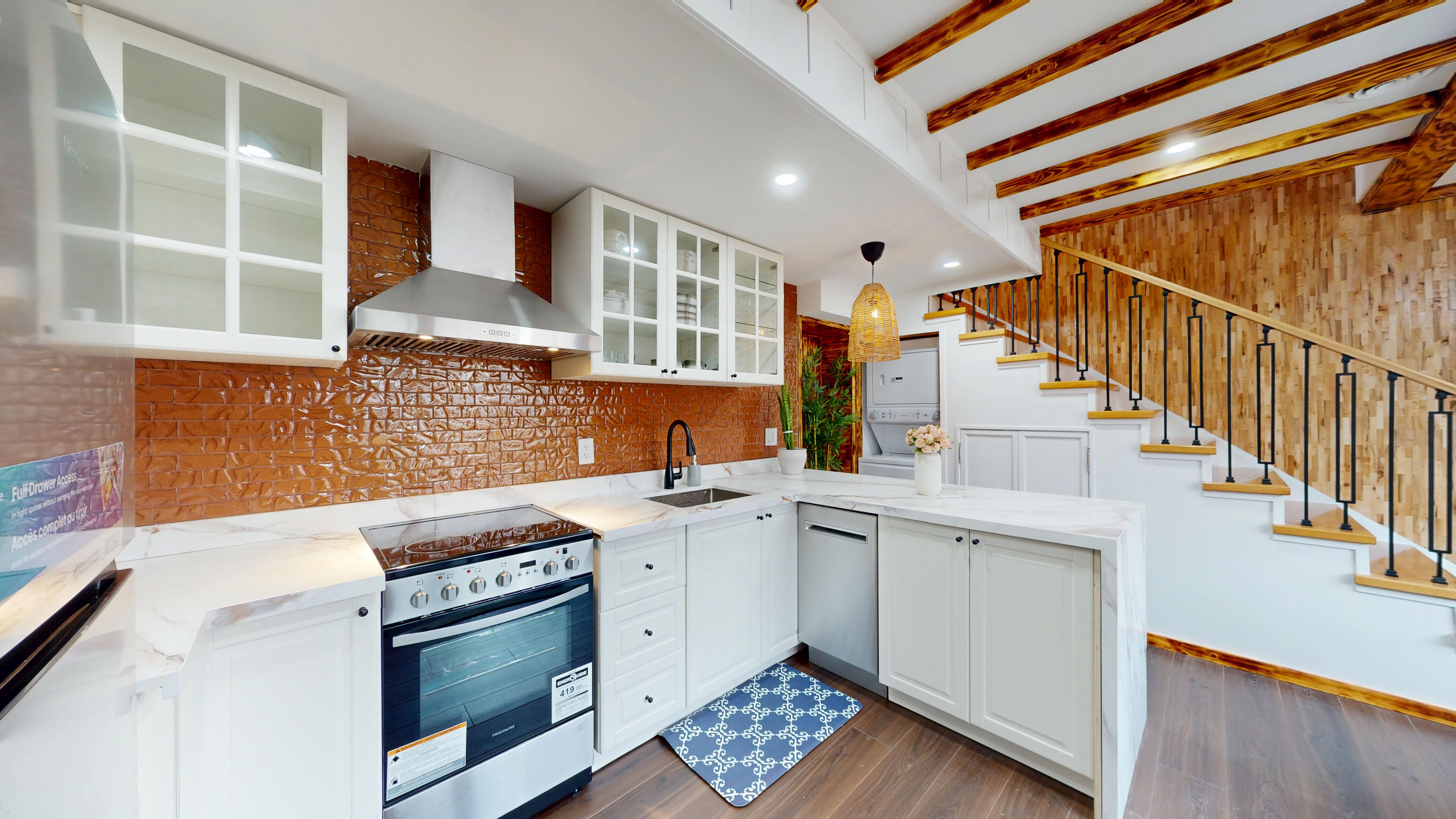 Kitchen with brick backsplash, marble counters and stainless appliances